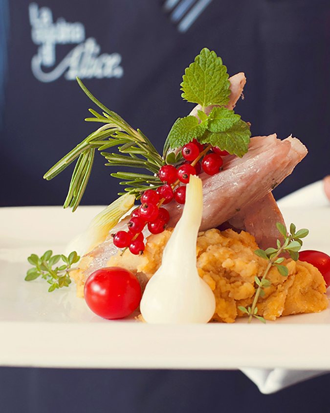 Ein Teller auf dem Weg in den Saal, mit der Schürze von La Cucina di Alice